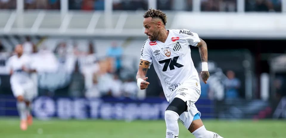 Jugador corriendo con balón en el campo de fútbol