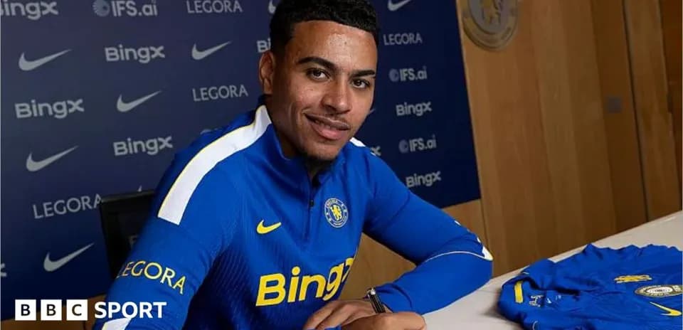 Jugador firmando contrato en mesa con camiseta