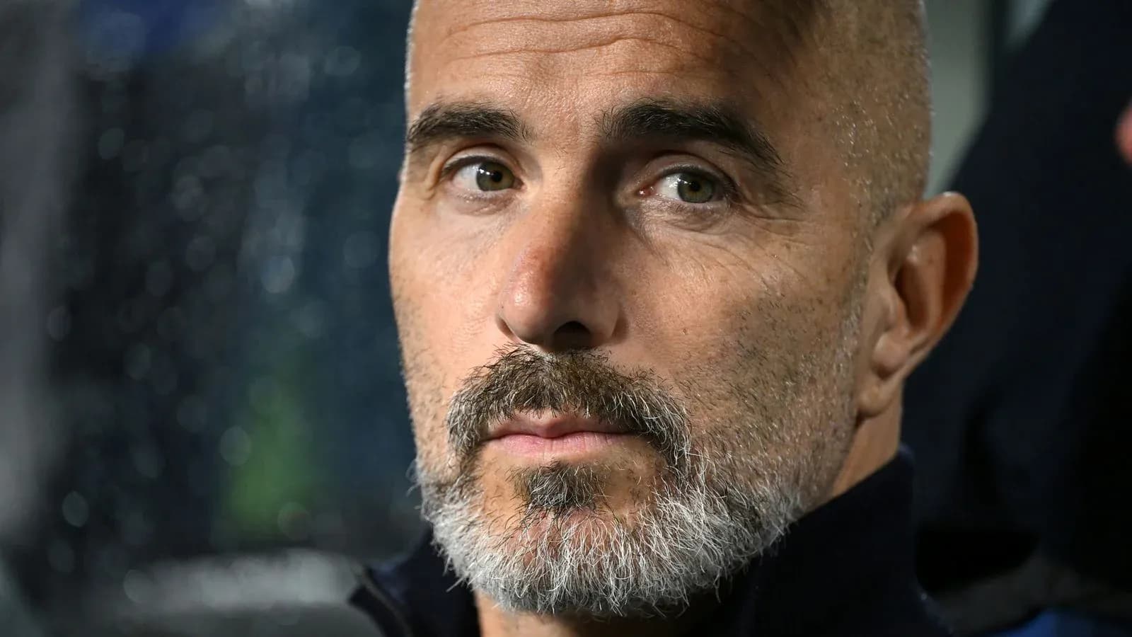 Entrenador con barba observando el partido