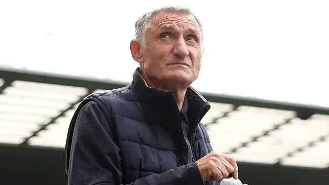 Hombre observando desde el estadio con abrigo oscuro