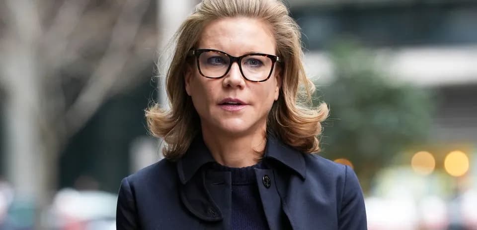 Mujer con gafas y abrigo oscuro caminando al aire libre