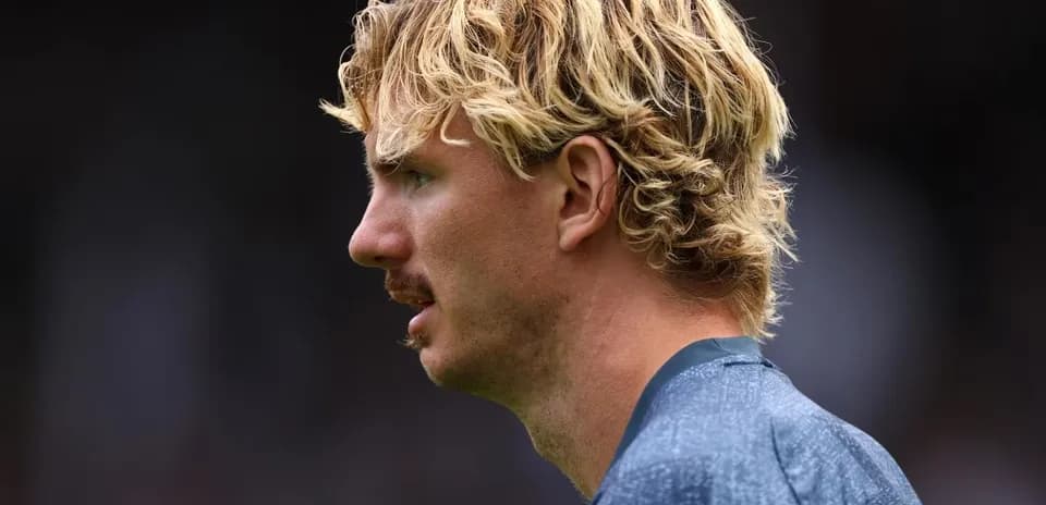 Jugador de perfil con cabello rubio rizado