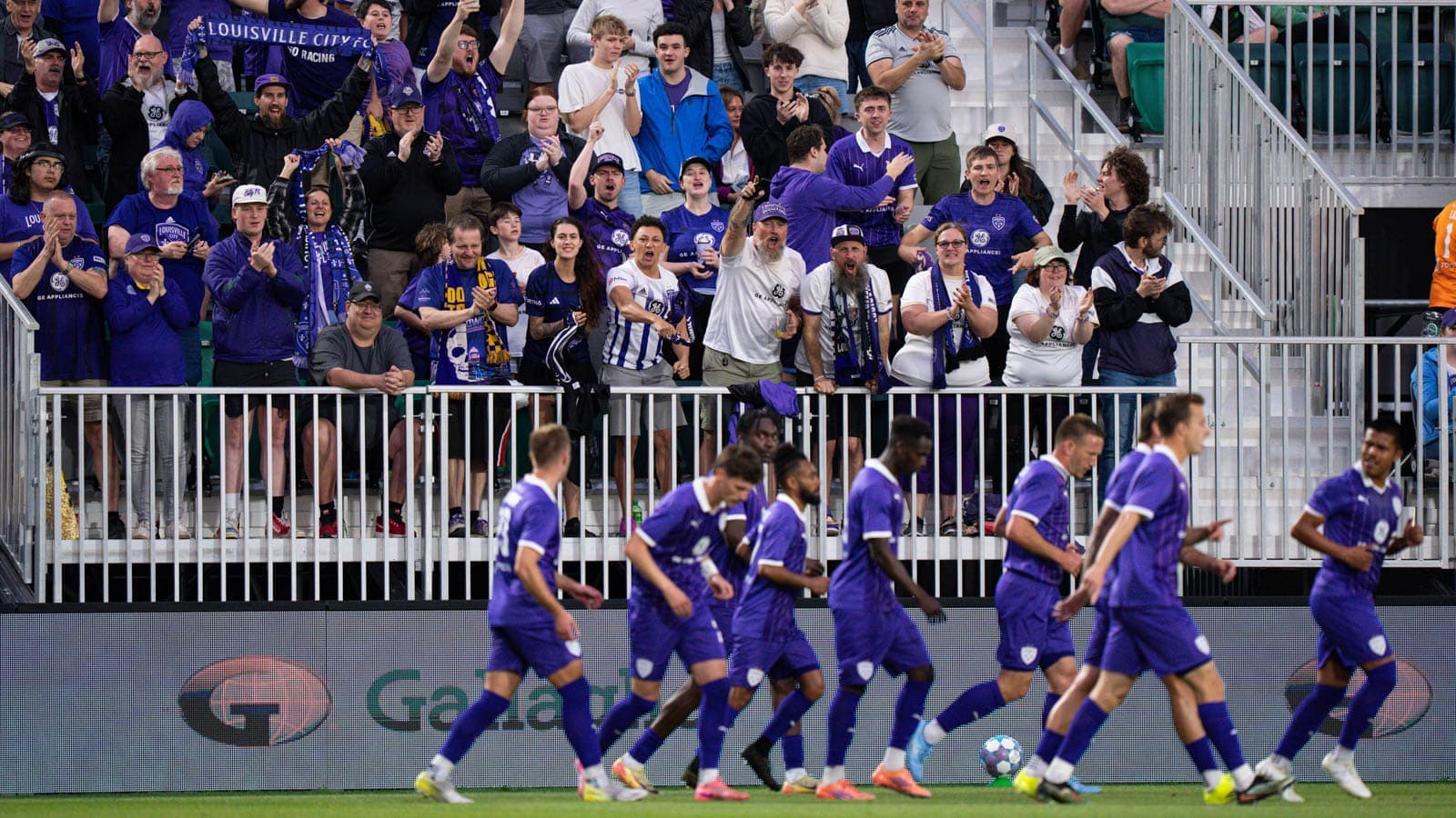 Aficionados de Louisville City animando en el estadio