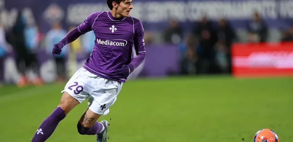 Jugador de Fiorentina corriendo tras el balón en el campo