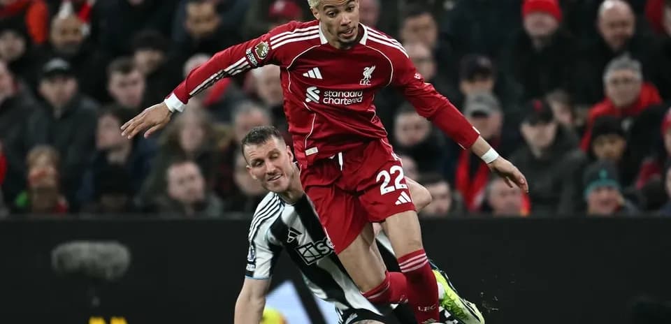 Un jugador de Liverpool cae ante un defensor de Newcastle