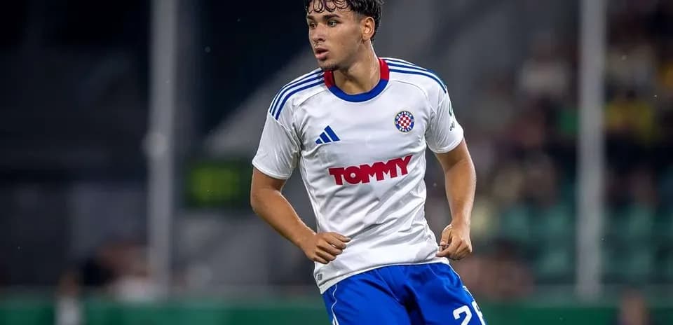 Jugador de fútbol corriendo en uniforme blanco y azul