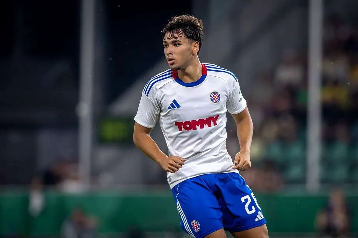 Jugador de fútbol corriendo en uniforme blanco y azul