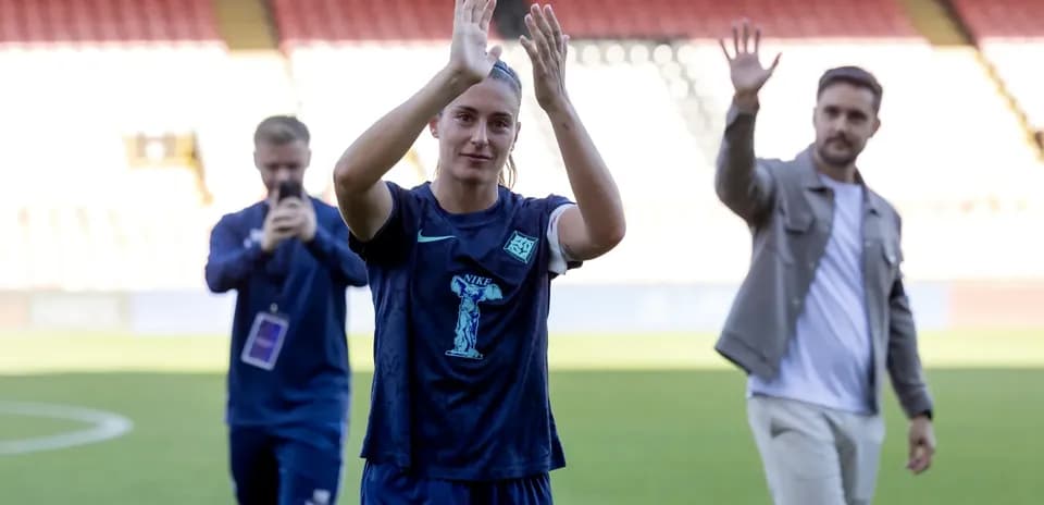 Jugadora aplaudiendo en el campo de fútbol