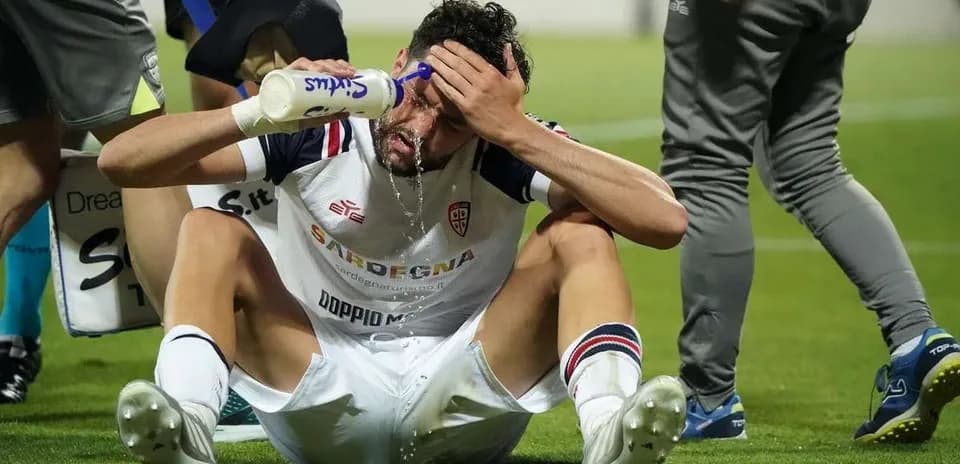 Jugador sentado recibiendo hidratación en el campo