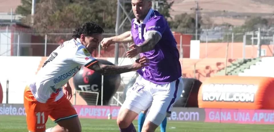 Jugadores compitiendo por el balón en el partido