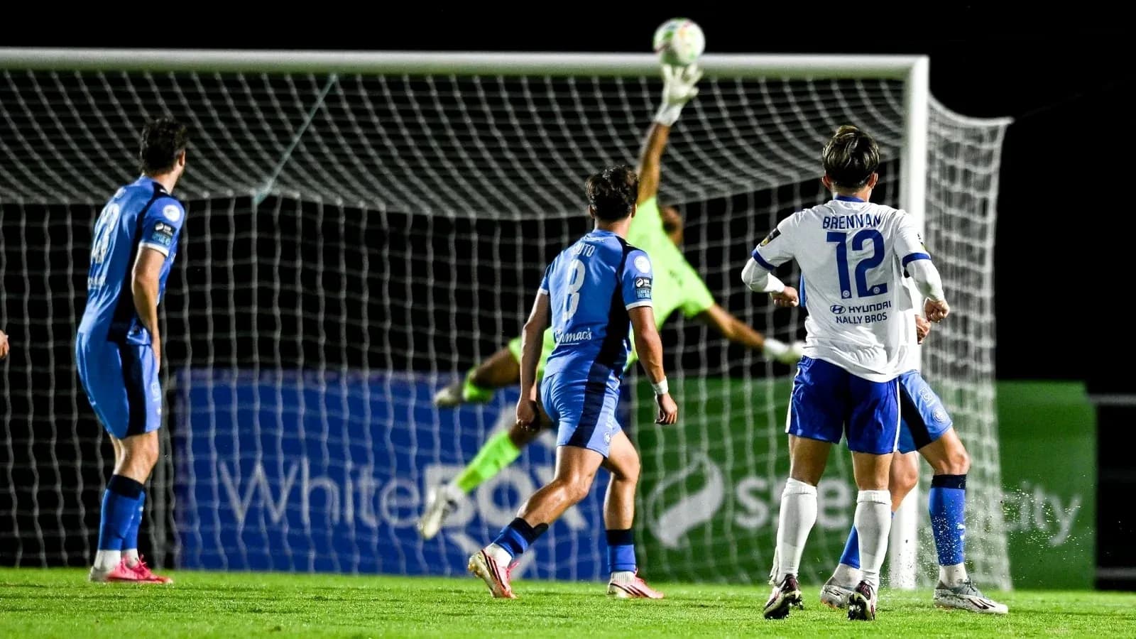 Portero saltando para detener un tiro en el partido
