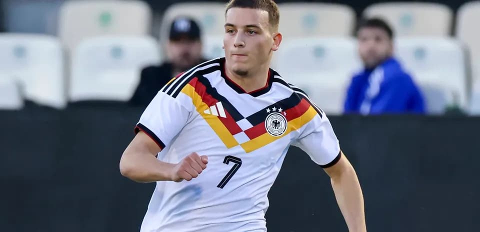 Jugador de Alemania corriendo con balón en el campo
