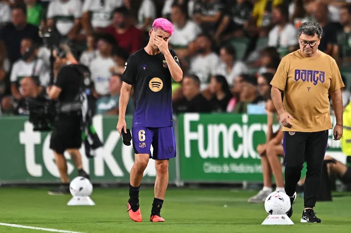 Jugador con cabello rosa camina junto al entrenador