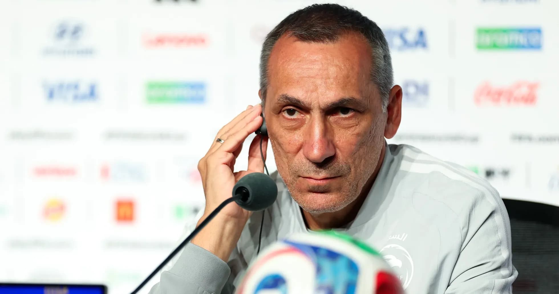 Entrenador en conferencia de prensa con auriculares