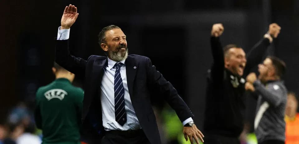 Entrenador celebrando con brazos alzados en la cancha