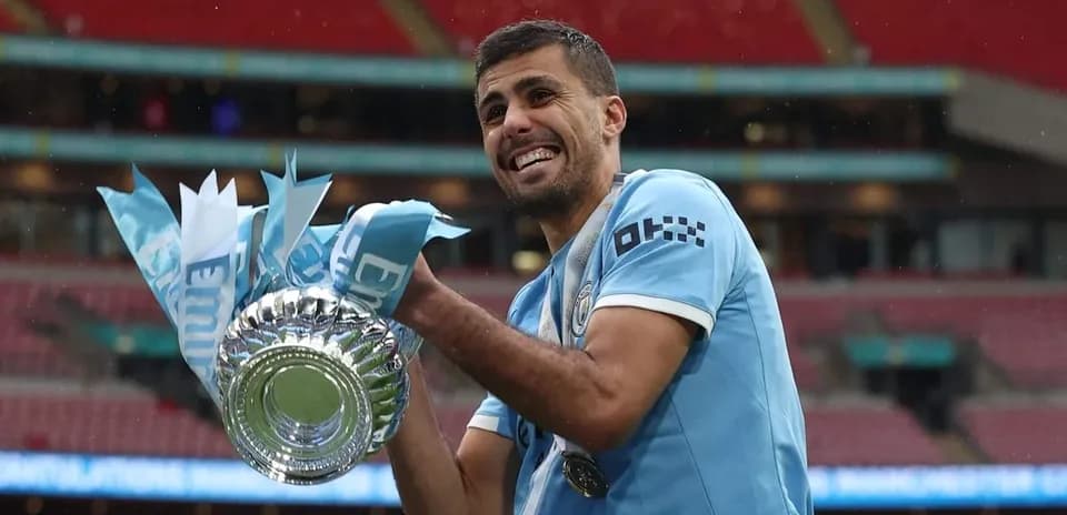 Jugador levantando trofeo en Wembley tras victoria