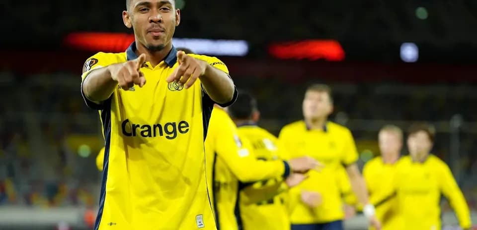 Jugador celebrando con compañeros en uniforme amarillo