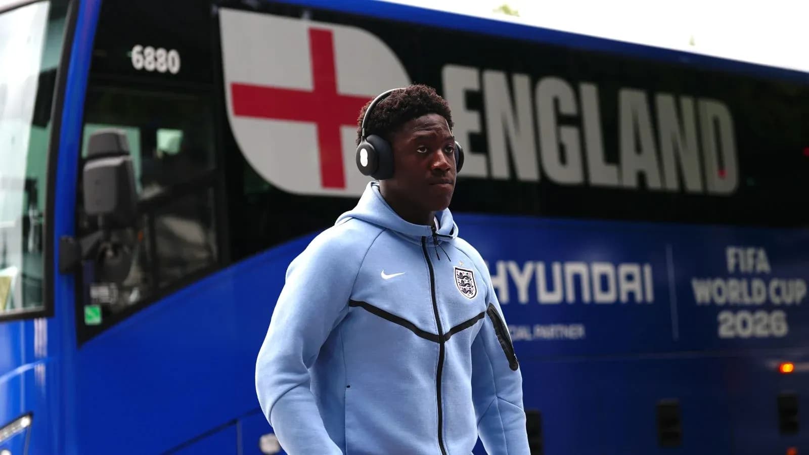 Jugador caminando junto al autobús de Inglaterra