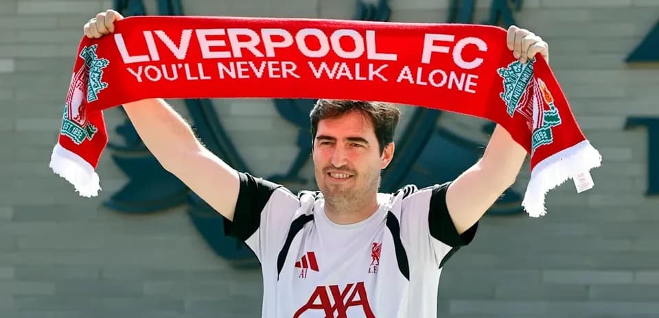 Jugador mostrando bufanda de Liverpool FC