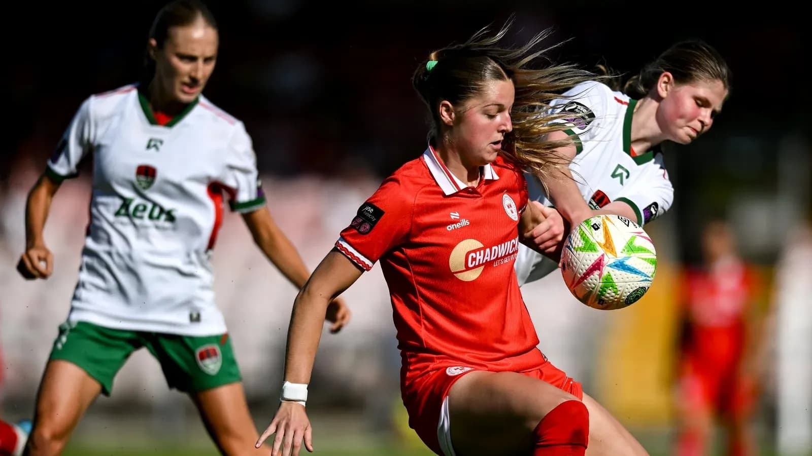Jugadora en rojo controlando el balón en partido