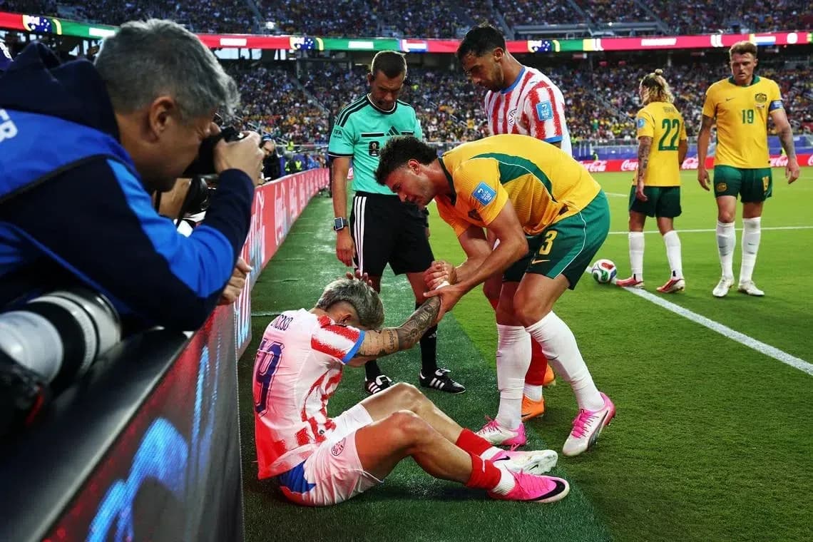 Jugador lesionado siendo asistido por rival y árbitro