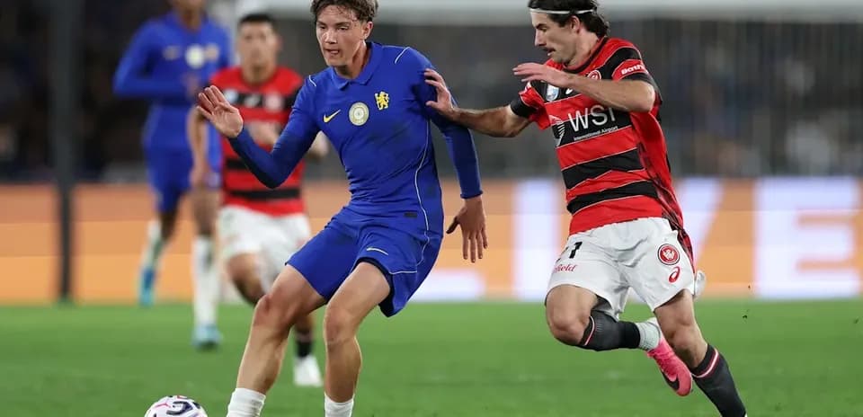 Jugador de azul driblando mientras es defendido