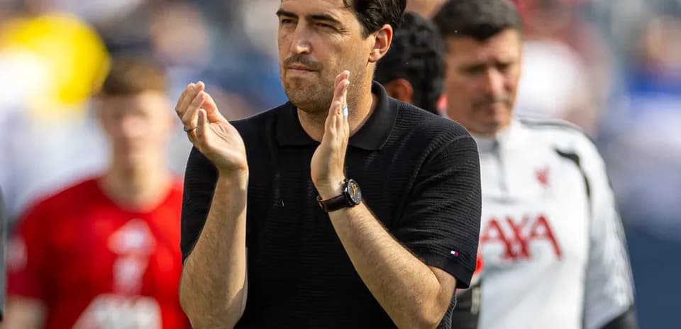 Entrenador aplaudiendo en el campo durante el partido
