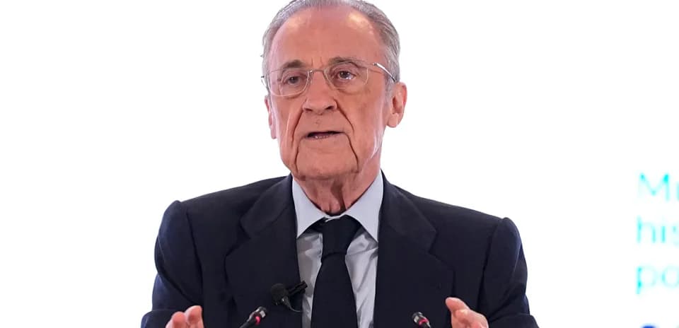 Hombre hablando en conferencia con micrófonos frente a él