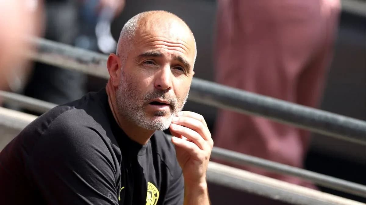 Entrenador sentado en la banca durante el partido
