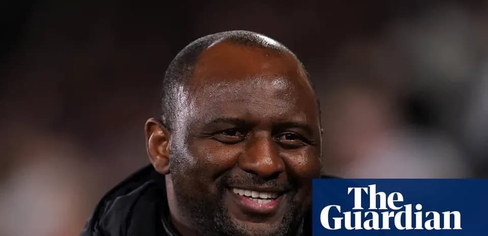 Entrenador sonriendo en el banquillo durante el partido