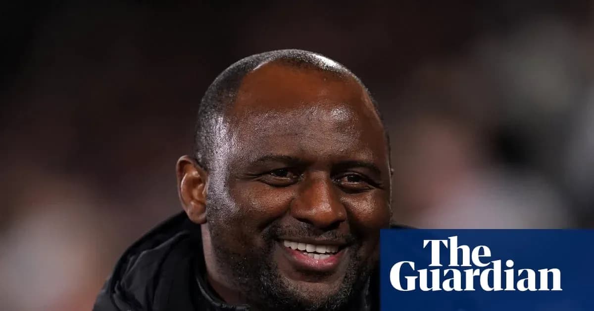 Entrenador sonriendo en el banquillo durante el partido