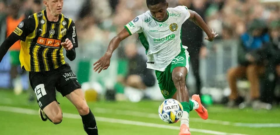 Jugador con balón siendo perseguido por oponente en partido