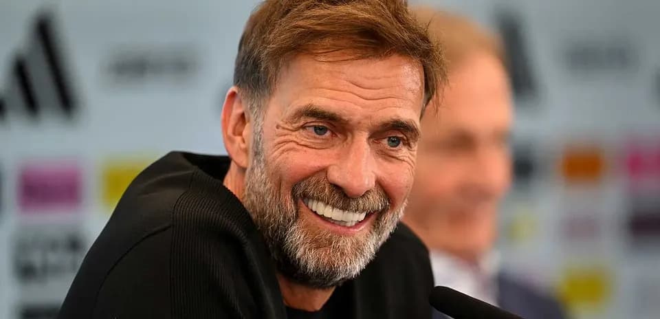 Entrenador sonriente en conferencia de prensa