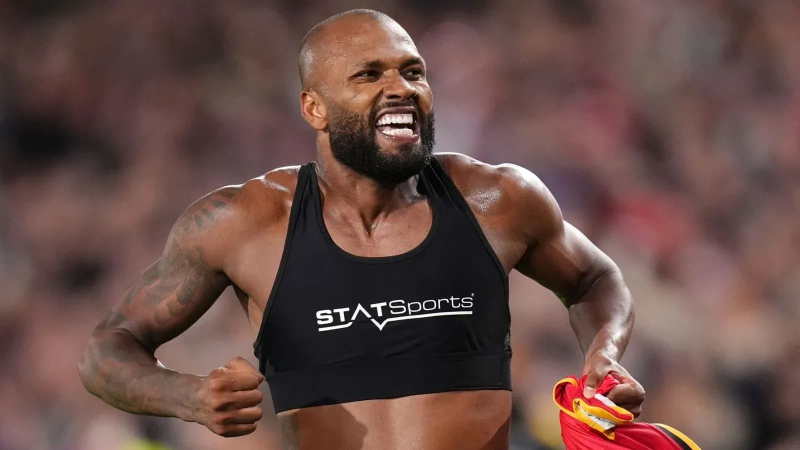 Atleta celebrando con camiseta en mano tras carrera