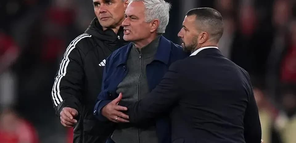 Entrenador siendo contenido por asistentes en el partido