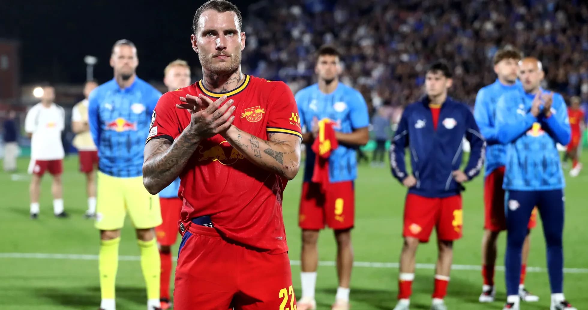 Jugador aplaudiendo con compañeros en el fondo