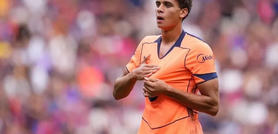 Jugador con camiseta naranja en el campo de fútbol