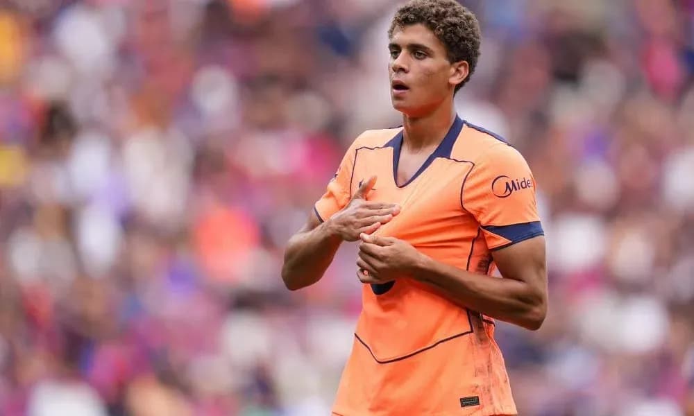 Jugador con camiseta naranja en el campo de fútbol