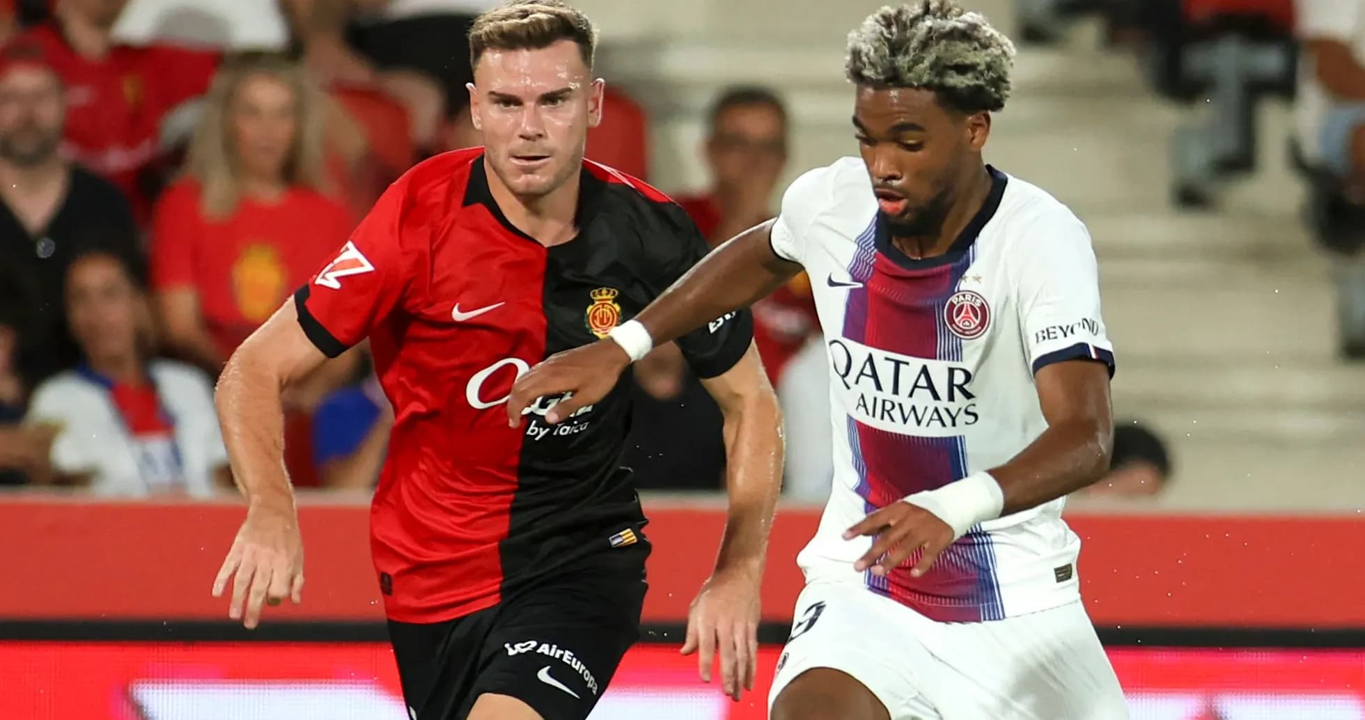 Jugadores de Mallorca y PSG compiten por el balón