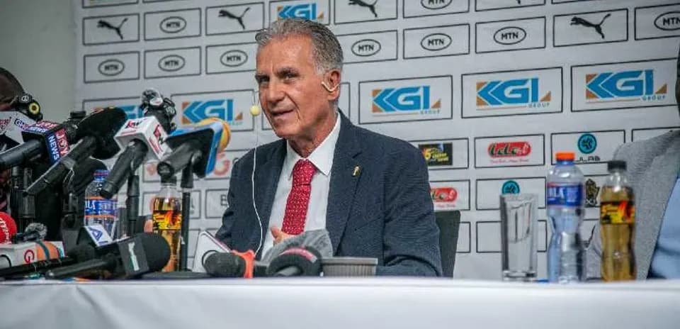 Entrenador hablando en rueda de prensa con micrófonos