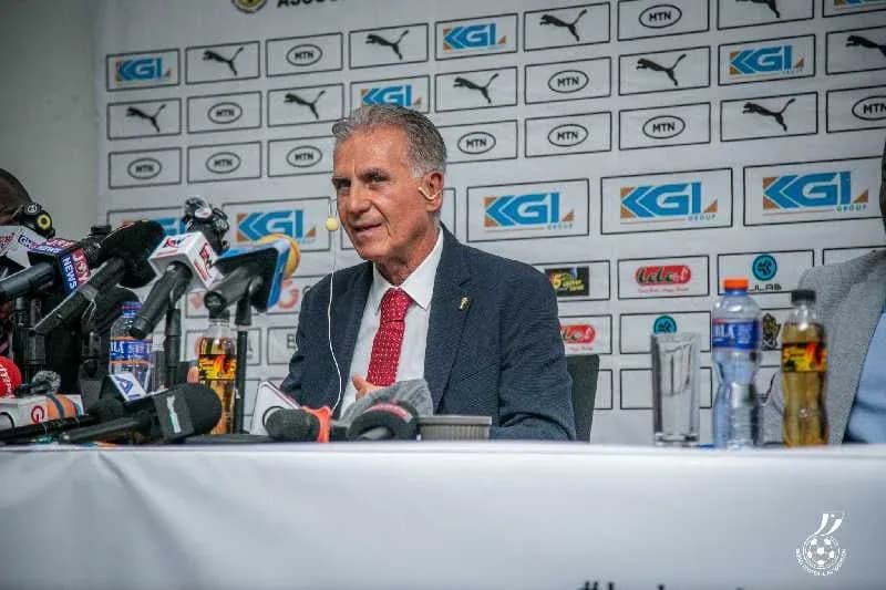 Entrenador hablando en rueda de prensa con micrófonos