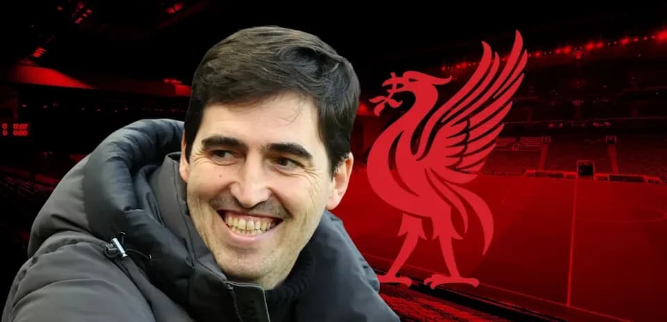 Entrenador sonriente frente al logo de Liverpool