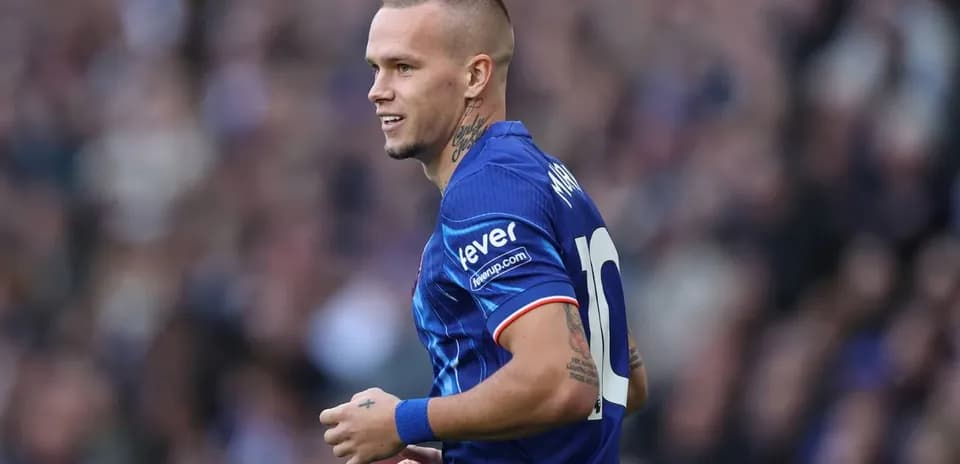 Jugador sonriendo en camiseta azul durante partido