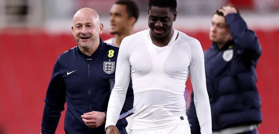 Entrenador y jugador sonriendo en el campo