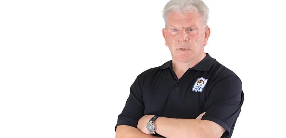 Entrenador de pie con los brazos cruzados