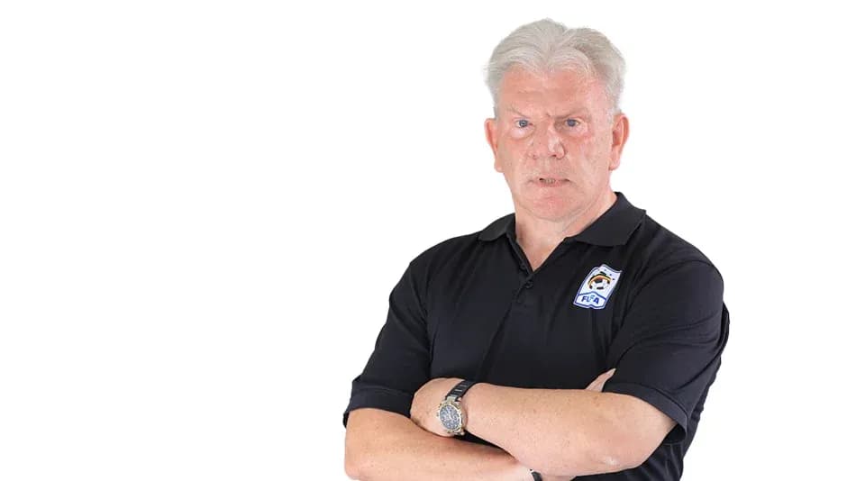 Entrenador de pie con los brazos cruzados