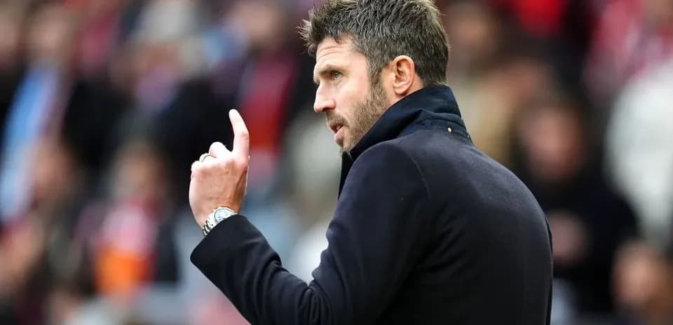 Entrenador gesticulando durante un partido de fútbol