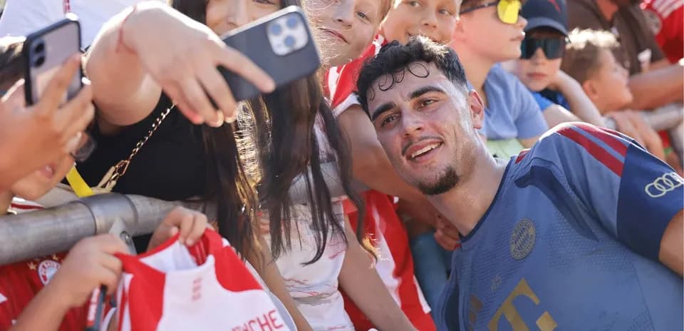 Jugador sonriente posando con fans después del partido