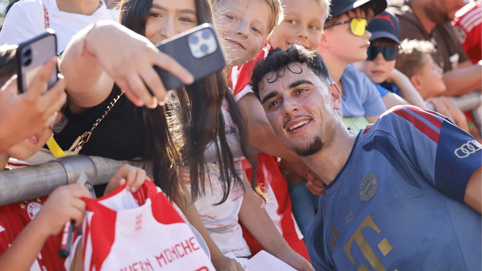 Jugador sonriente posando con fans después del partido