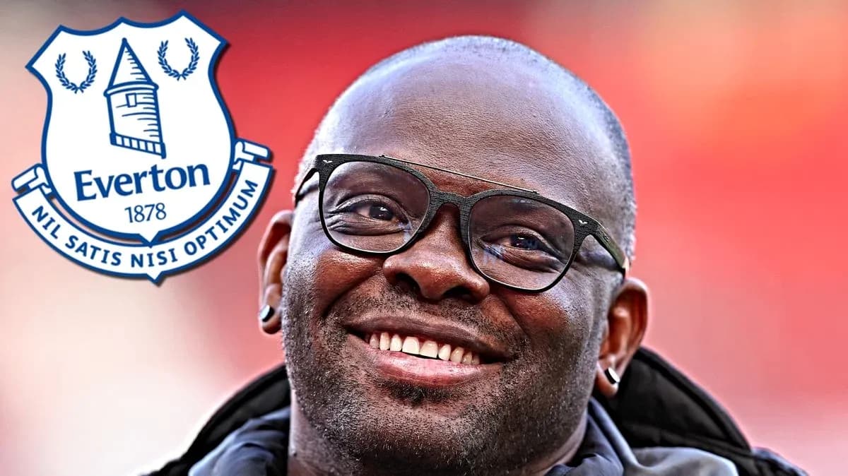 Hombre sonriendo con gafas y escudo de Everton